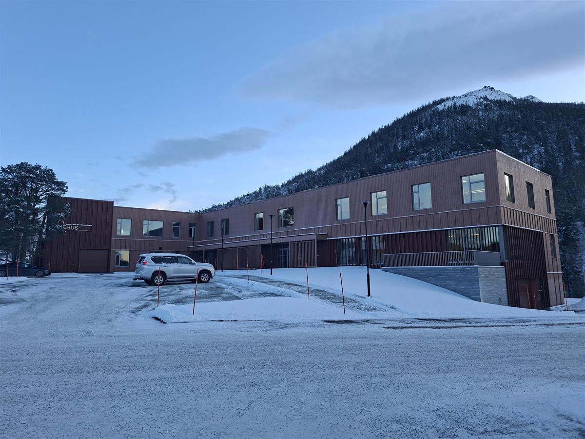 helsehuset sett forfra, med mælanakken i bakgrunnen. - Klikk for stort bilde